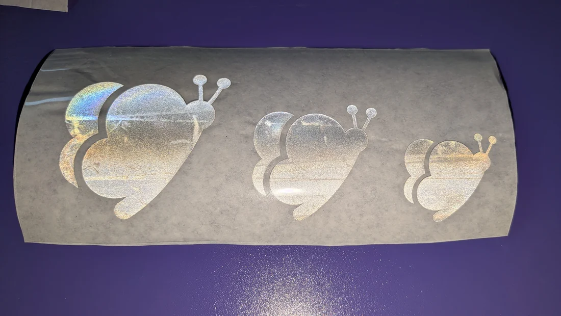 Drei reflektierende Schmetterlinge in drei Größen auf der Trägerfolie
